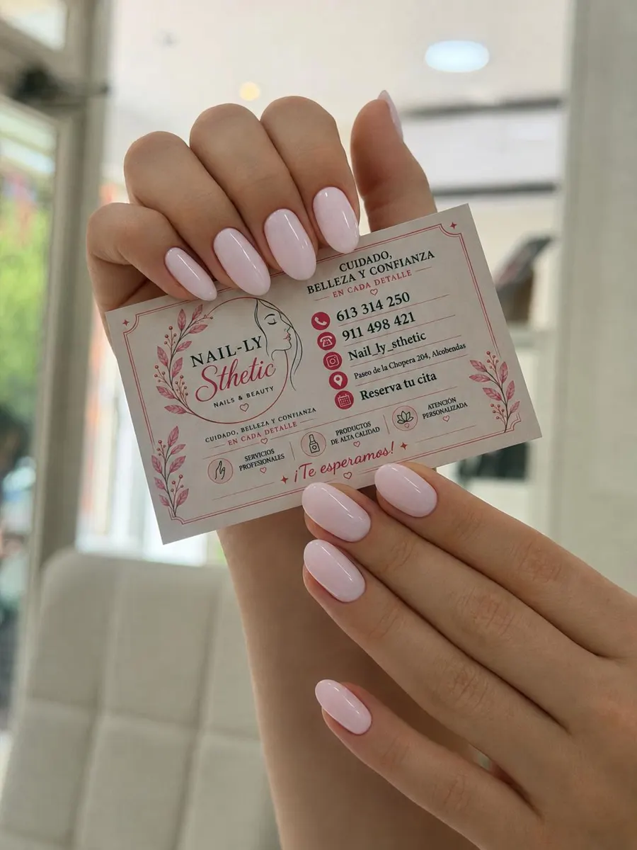 Manos con manicura rosa lechoso sosteniendo la tarjeta de NAIL-LY Sthetic